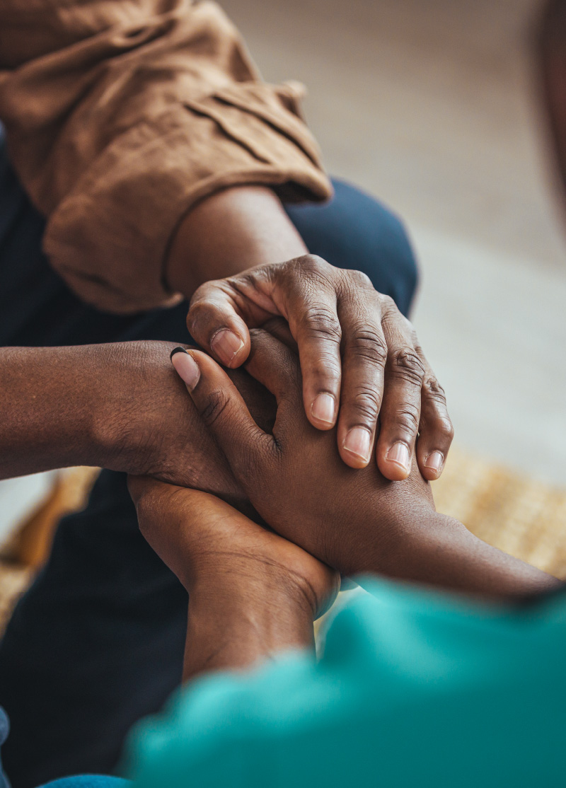 Photo close-up of a man's hands holding a woman's hands in comfort.